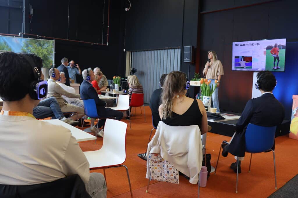 Bezoekers met koptelefoon bij het silent seminar terras